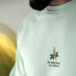 Чоловік у м'ятній оверсайз-футболці Kyiv Digital «Як мене не любити» з принтом цвіту каштана